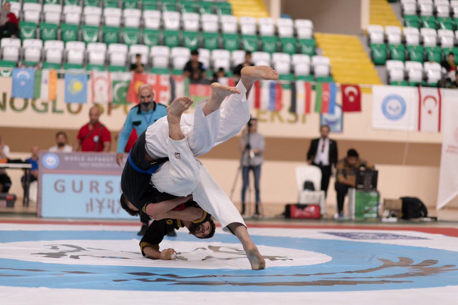 Rakibini omuz üstünden atan sporcu ve hakem